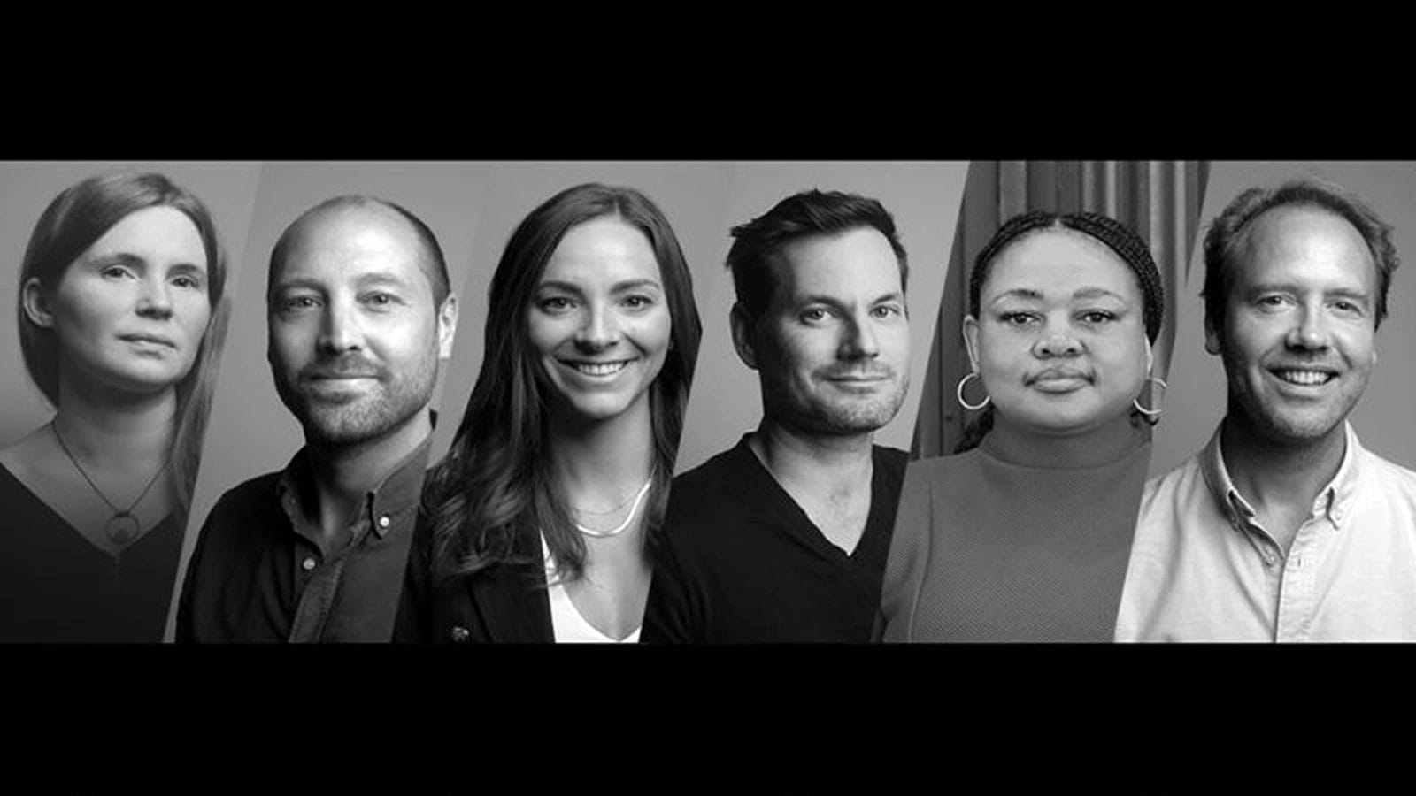 A black-and-white photo shows six people standing side by side, facing forward. There are three women and three men, all wearing casual or business-casual clothing, with neutral or slight smiles, against a plain background.