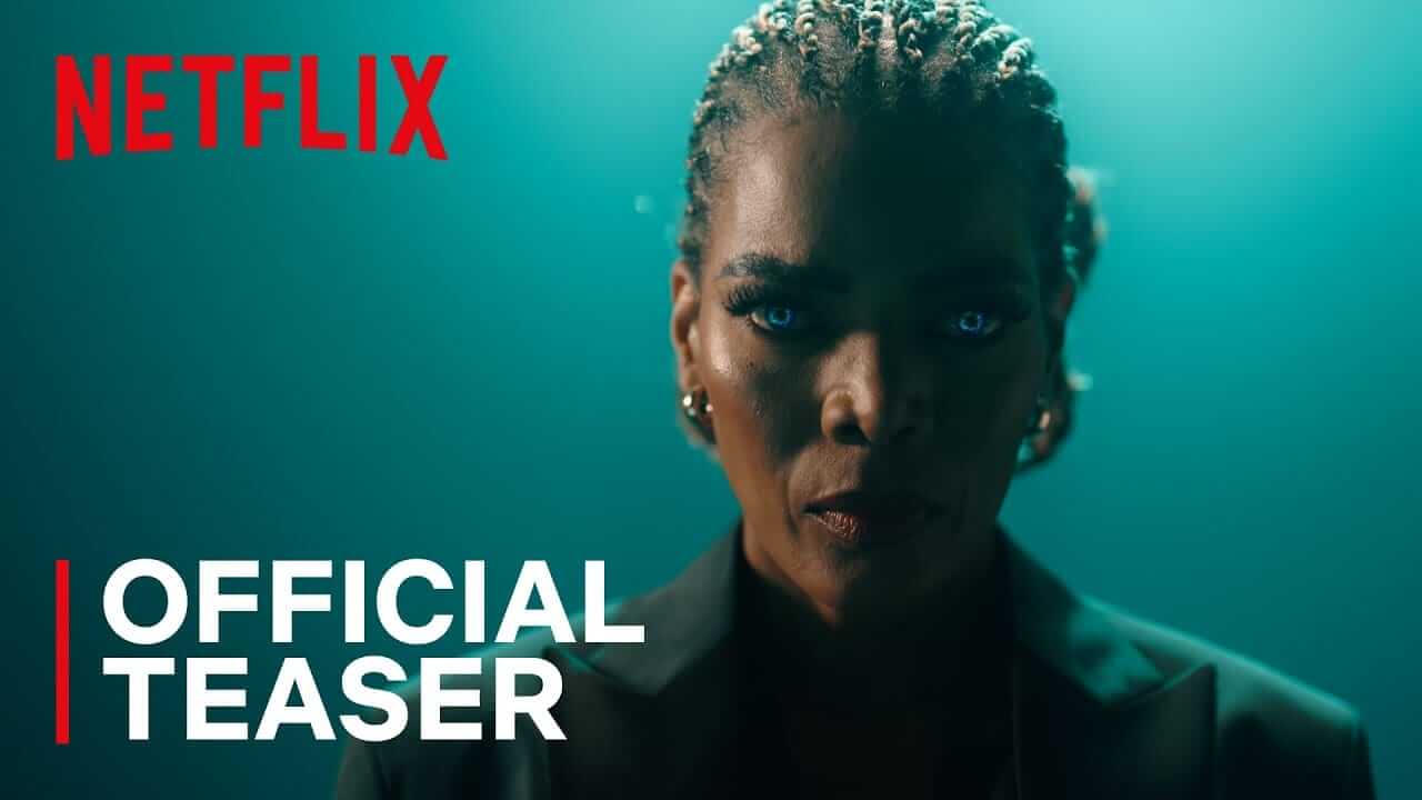A person with braided hair, glowing blue eyes, and serious expression stands against a teal background. They wear a dark blazer and hoop earrings. The image features the red Netflix logo and white text reading “OFFICIAL TEASER” in the lower left corner.