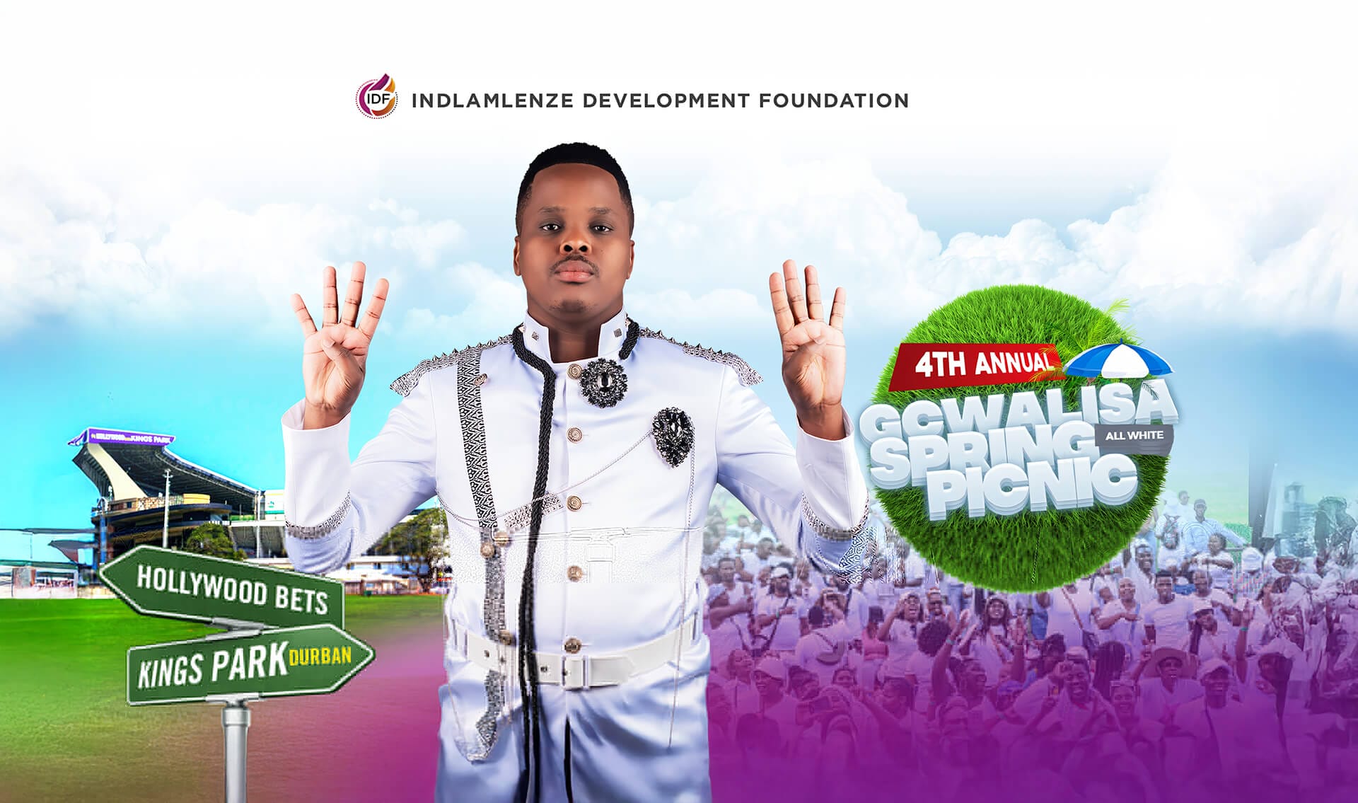 A man in a white, ornate suit stands gesturing with both hands. Behind him are a stadium, a green sign reading 