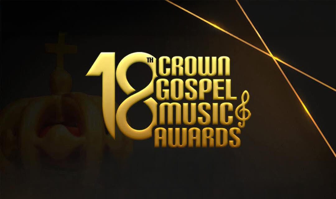 Golden text reads "18th Crown Gospel Music Awards" with a musical note beside "Music." The background is black with subtle orange diagonal lines and a faint image of a crown and cross behind the text.