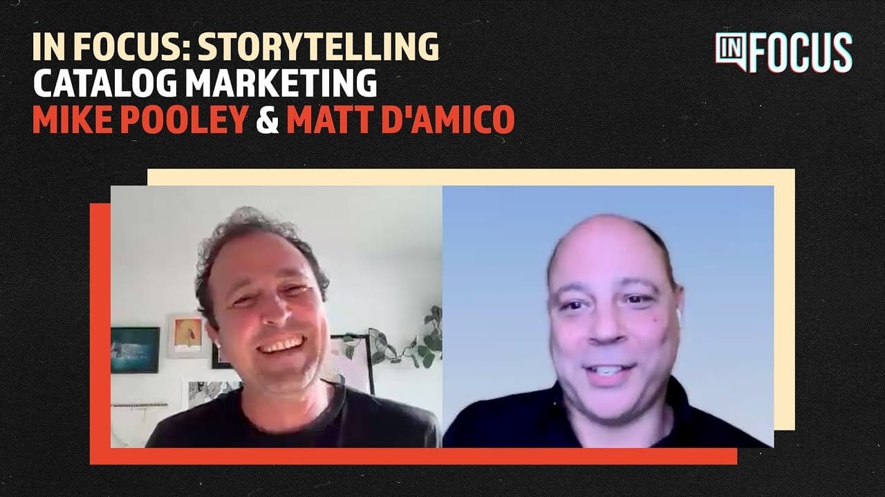 A split-screen webinar image features two smiling men—Mike Pooley (left, curly hair, white shirt, background with plant) and Matt D’Amico (right, bald, dark shirt, blue background)—with bold text: “In Focus: Storytelling in Catalogue Marketing.”.