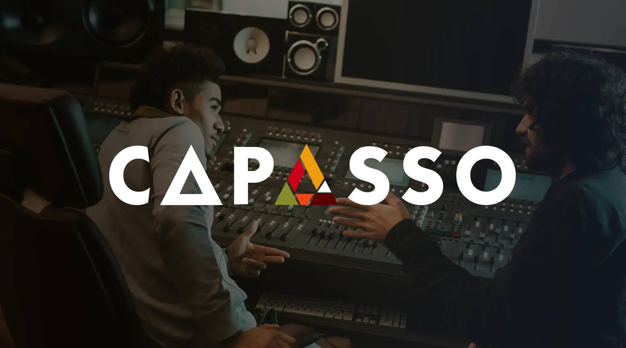 Two people sit at a large audio mixing desk in a recording studio, engaged in conversation. The word “CAPASSO” in bold white letters overlays the image, with the “A” designed as a stylised triangle with red and yellow accents.